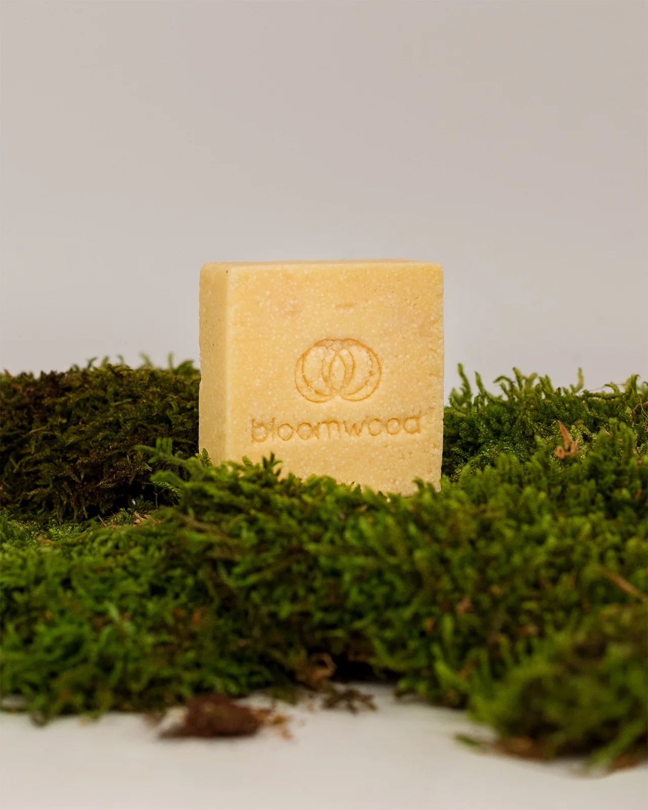 Feste Heilpflanzen-Seife von bloomwood mit eingeprägtem Logo auf Moos