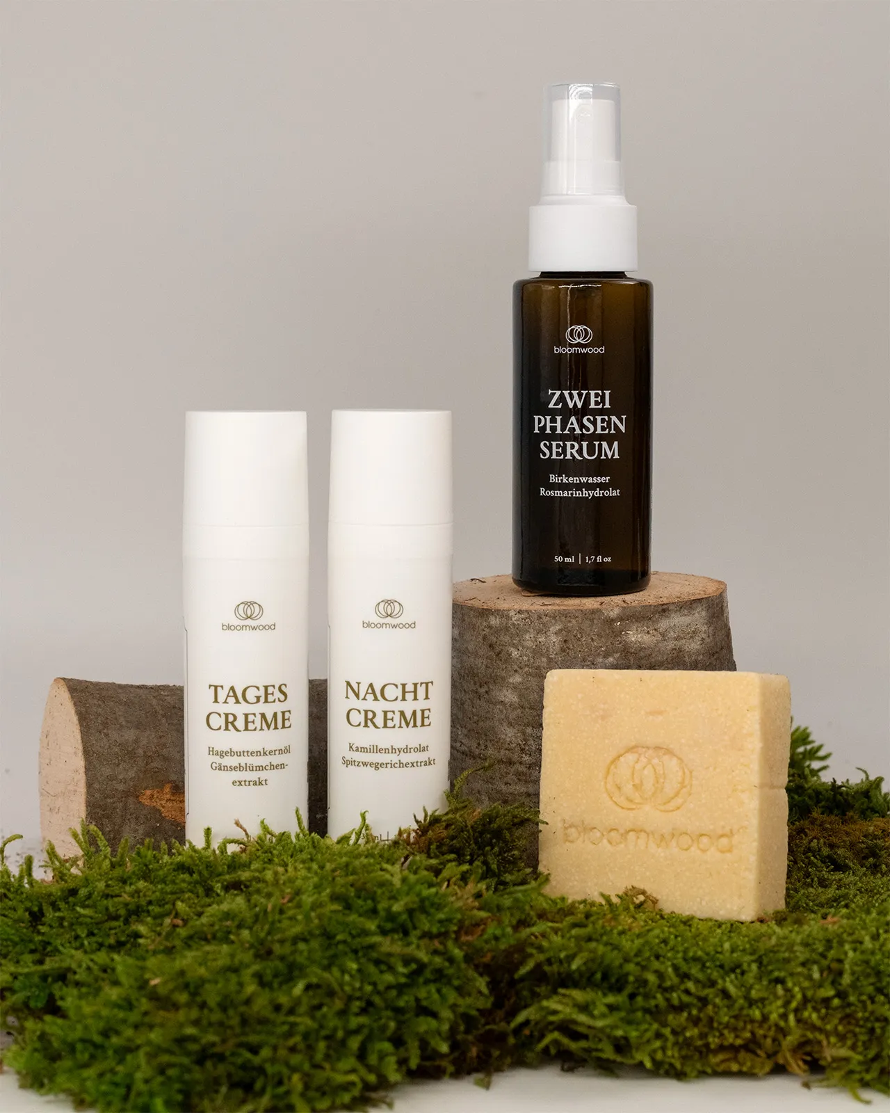 Tagescreme, Nachtcreme und Zwei-Phasen-Serum von bloomwood auf Holzscheiten